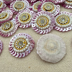 Decorative buttons with sequins and beads on a textured surface