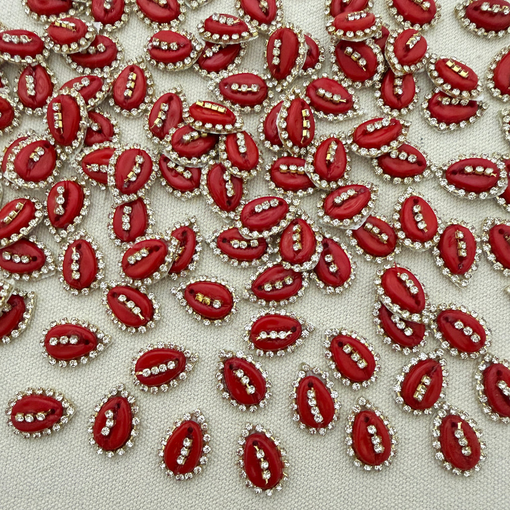 Red embellishments with rhinestones on a light fabric background