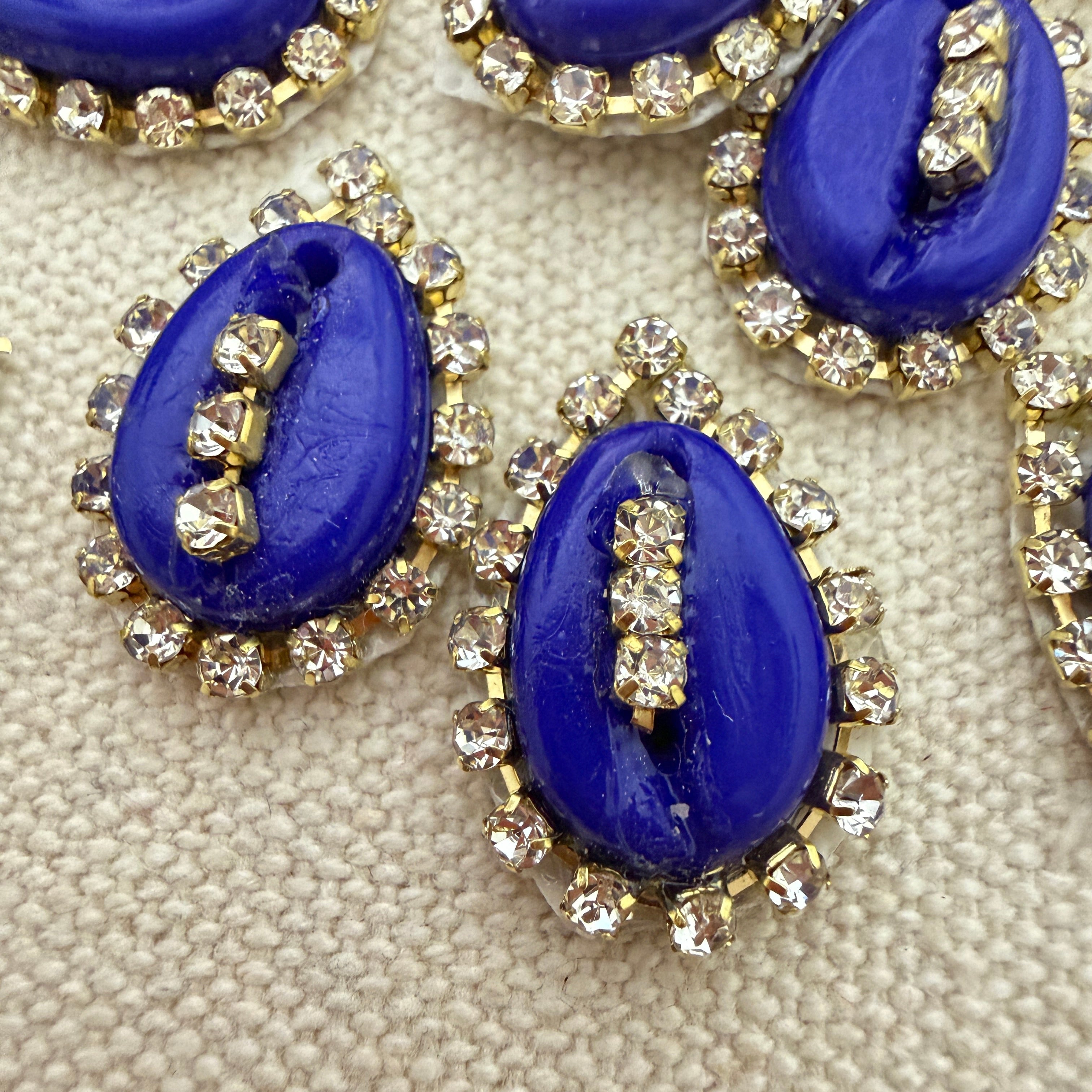 Blue cabochon stones with rhinestone accents on a beige fabric background