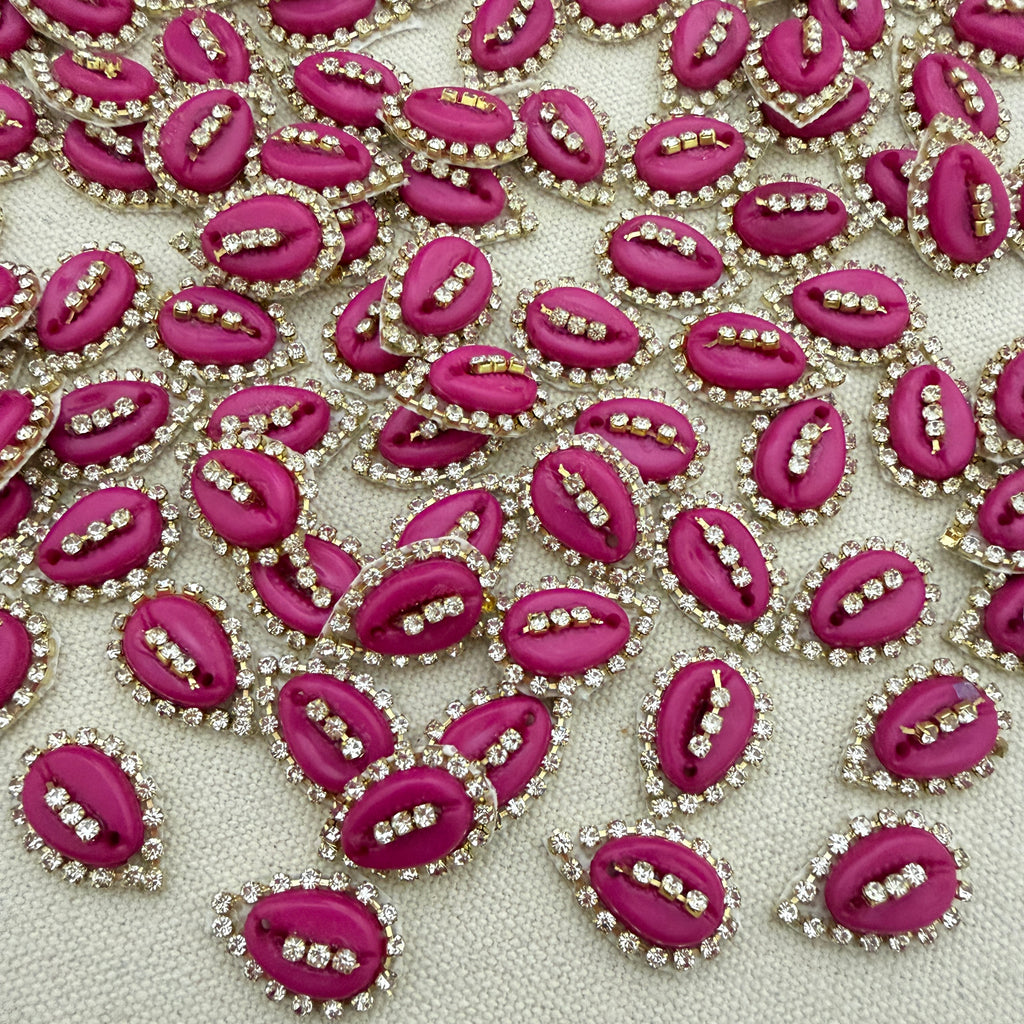 Pink lip-shaped embellishments with rhinestones on a light gray background