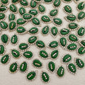 Green leaf-shaped decorative elements with rhinestones on a textured surface