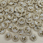 Close-up of decorative buttons with pearls and crystals on a beige fabric background