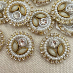 Decorative buttons with pearls and crystals on a textured beige background