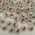 Close-up of decorative buttons with red centers, pearls, and crystals on a beige background
