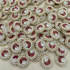 Close-up of decorative elements with pearls, red stones, and gold accents on a beige background