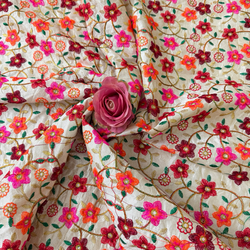 Floral embroidered fabric with a pink rose on top