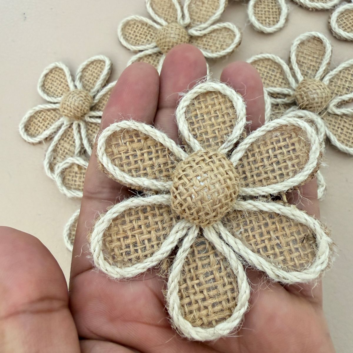 Burlap daisy flower patch held in hand showing size and texture