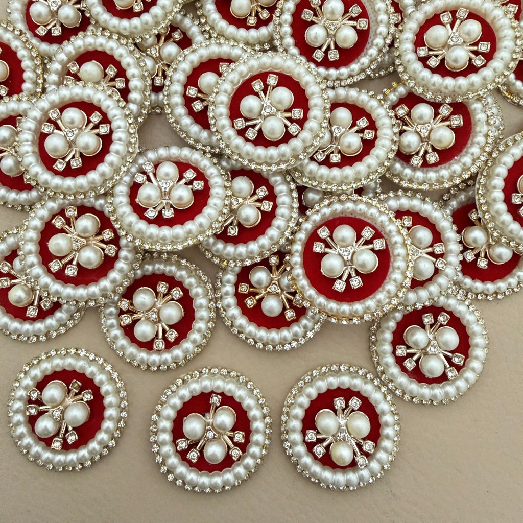 Close-up of pearl cluster center with rhinestone gold-tone frame on red velvet patch