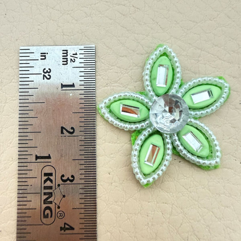Close-up of two green rhinestone flower patches