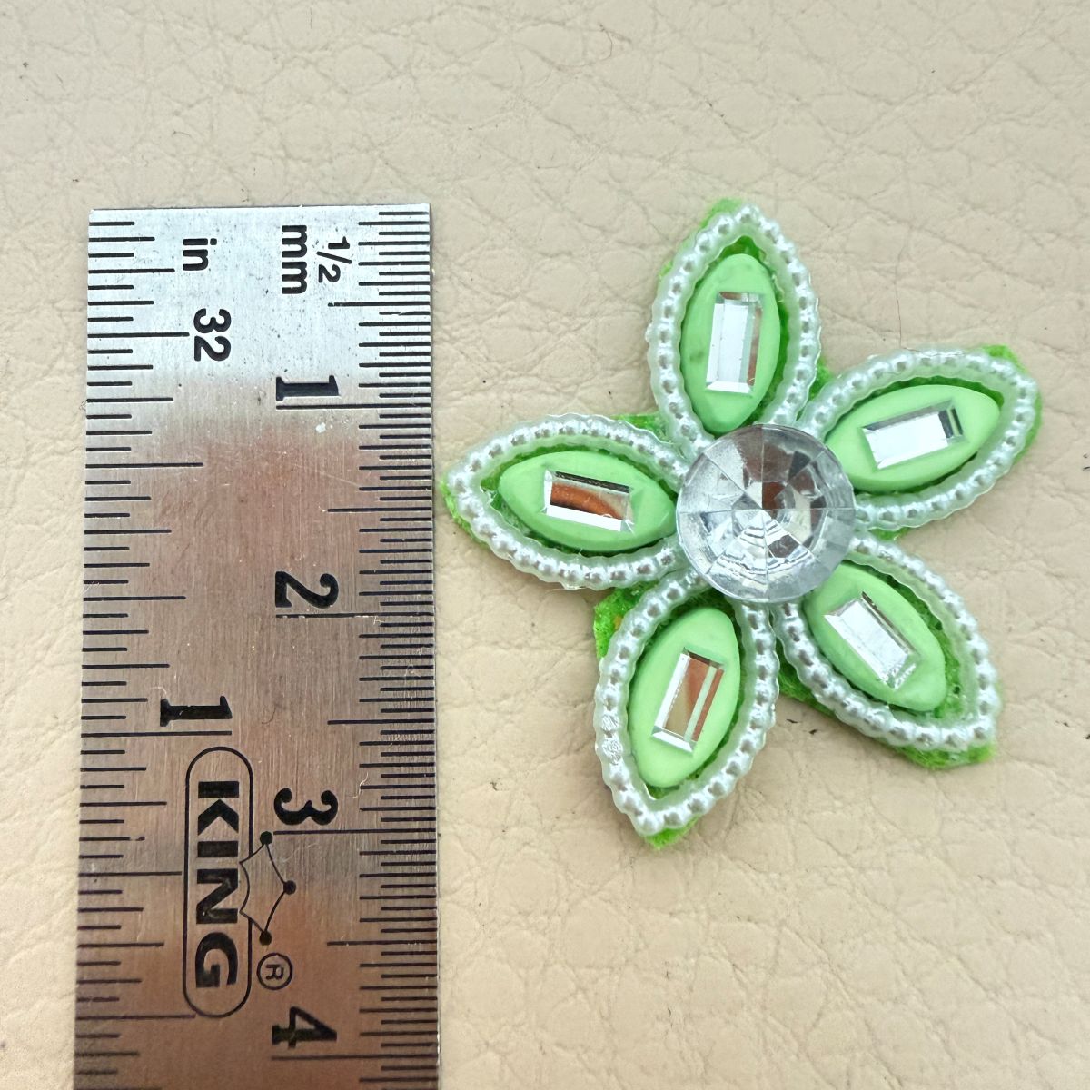 Close-up of two green rhinestone flower patches