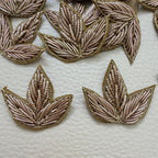 Close-up of a gold metallic three-leaf floral fabric patch