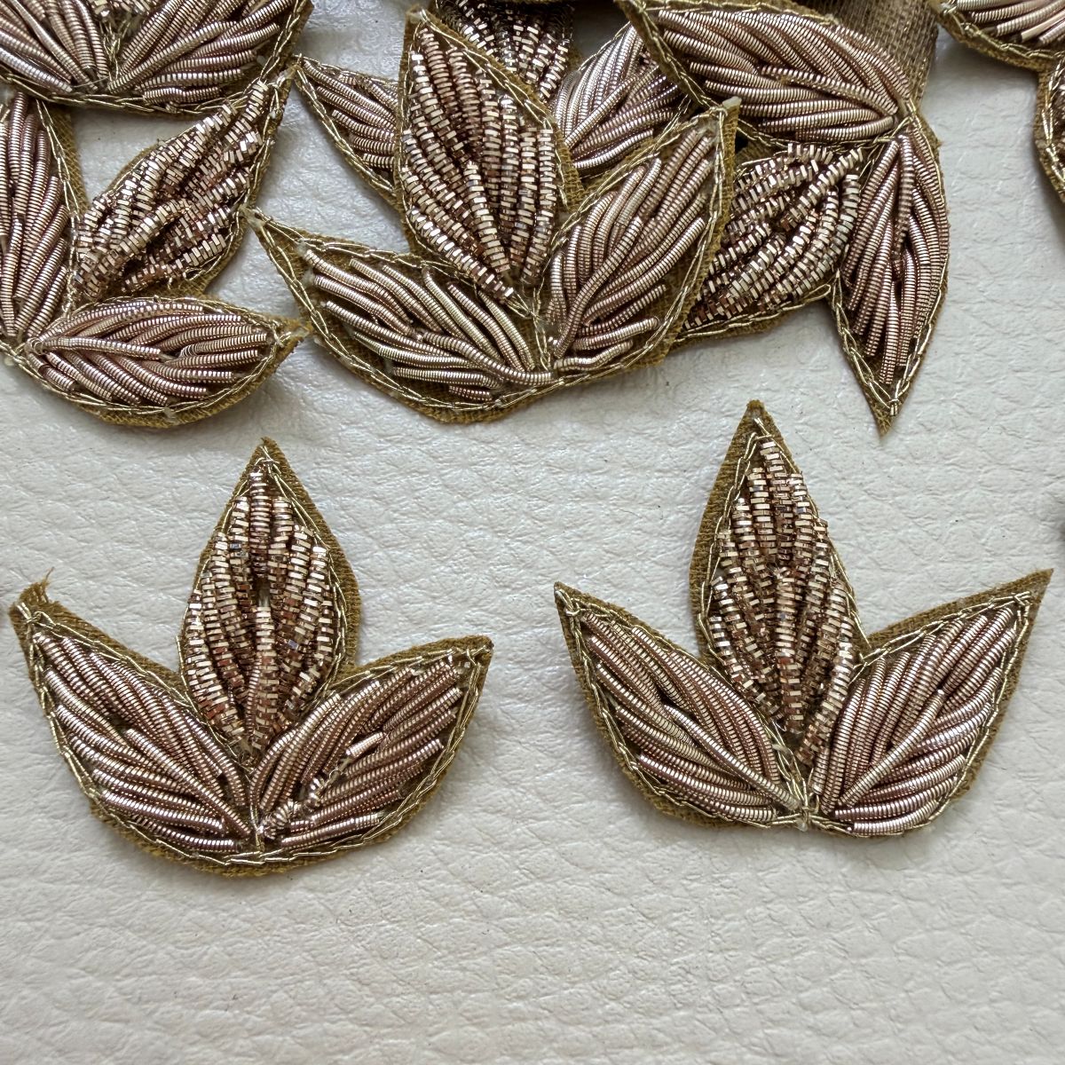 Close-up of a gold metallic three-leaf floral fabric patch