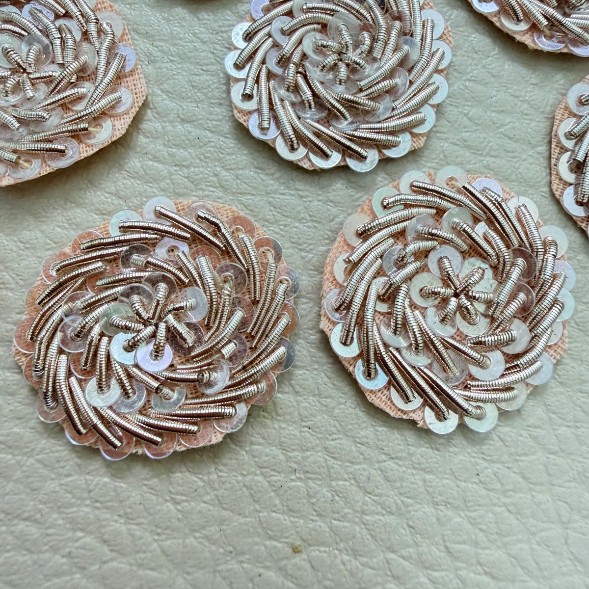 Group of round rose gold metallic coil floral patches with layered sequins