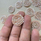 Close-up of rose gold metallic coil rosette patches with iridescent sequins