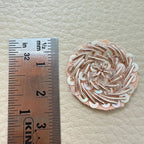 Small round rose gold metallic coil and sequin floral patch shown in hand for scale