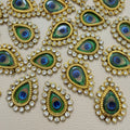 Front and mesh back of gold-tone teardrop patch with peacock-eye center and clear rhinestones