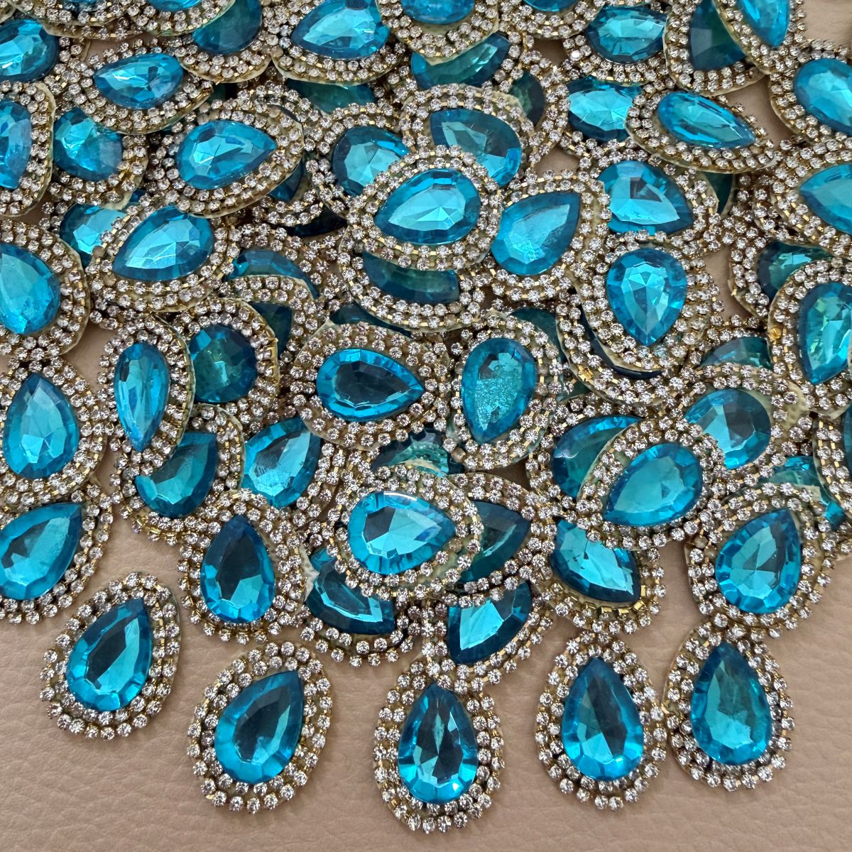 Front and fabric backing of aqua blue teardrop crystal rhinestone patch