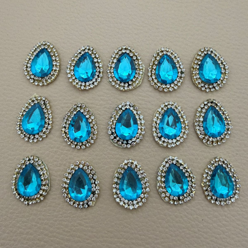 Close view of vivid aqua blue teardrop stones with clear rhinestone borders