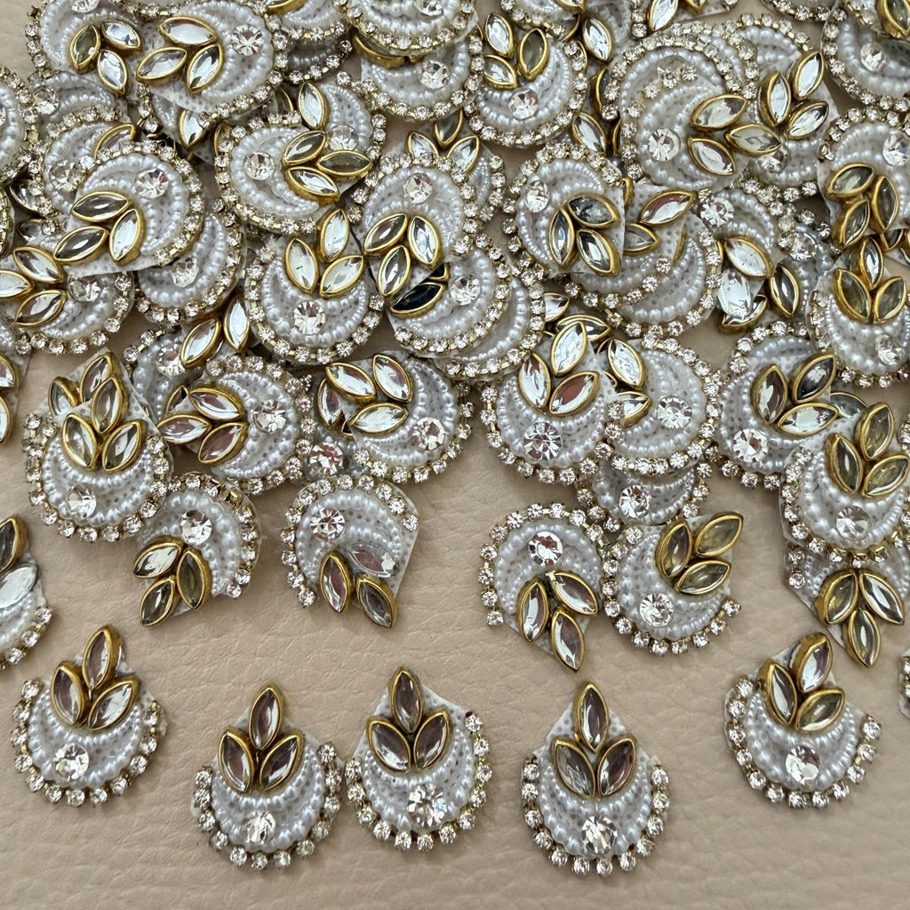 White crescent patch with layered pearl-like beads, clear rhinestones, center crystal, and gold marquise accents