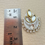 Close view of two white beaded crescent patches with crystal centers and gold-tone accents