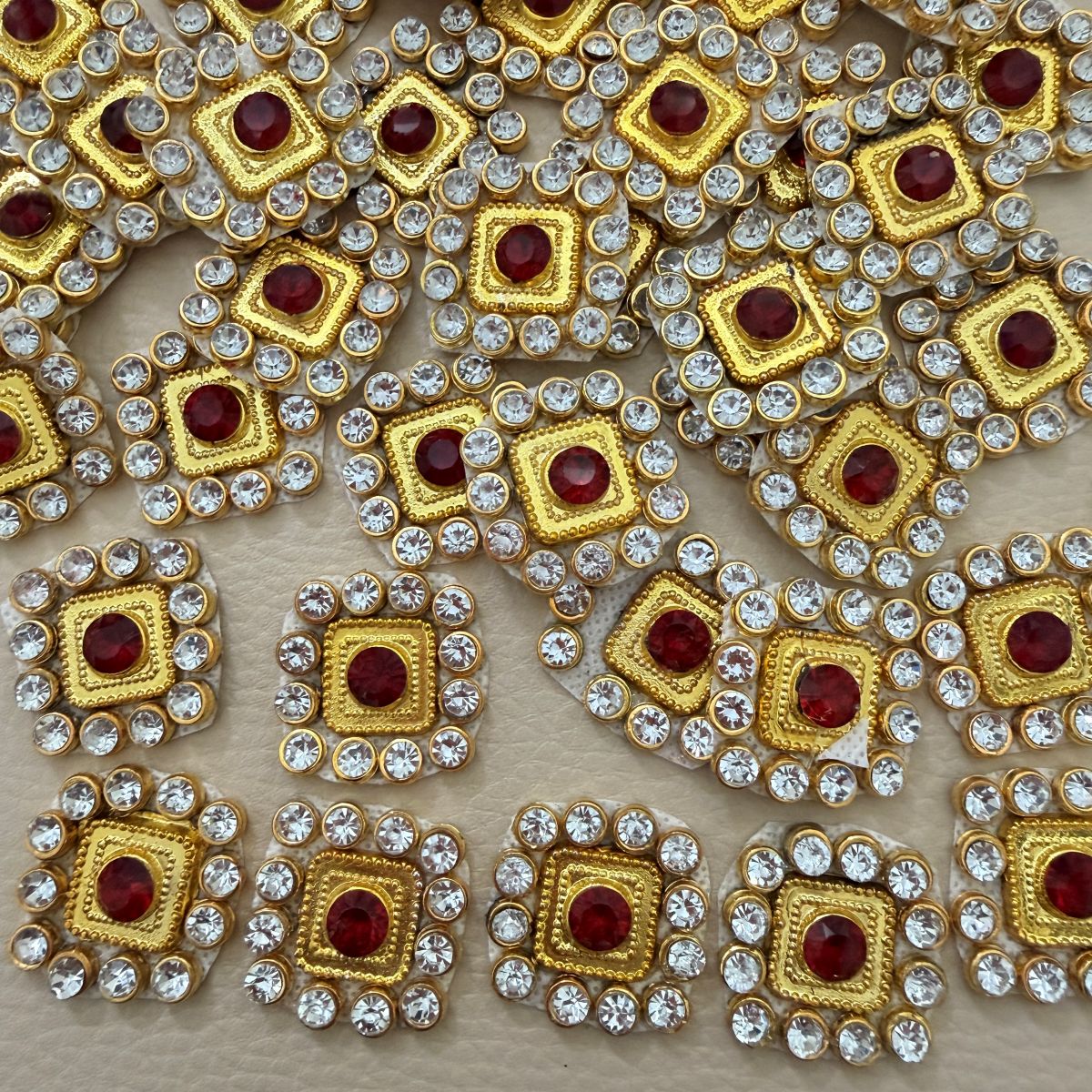 Front and back view of ruby red square patch with clear rhinestones and gold-tone frame