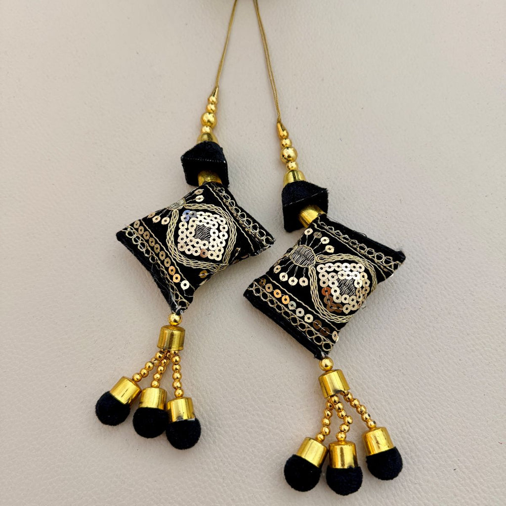 Black and gold embroidered tassels with shimmering sequin details and soft black ends