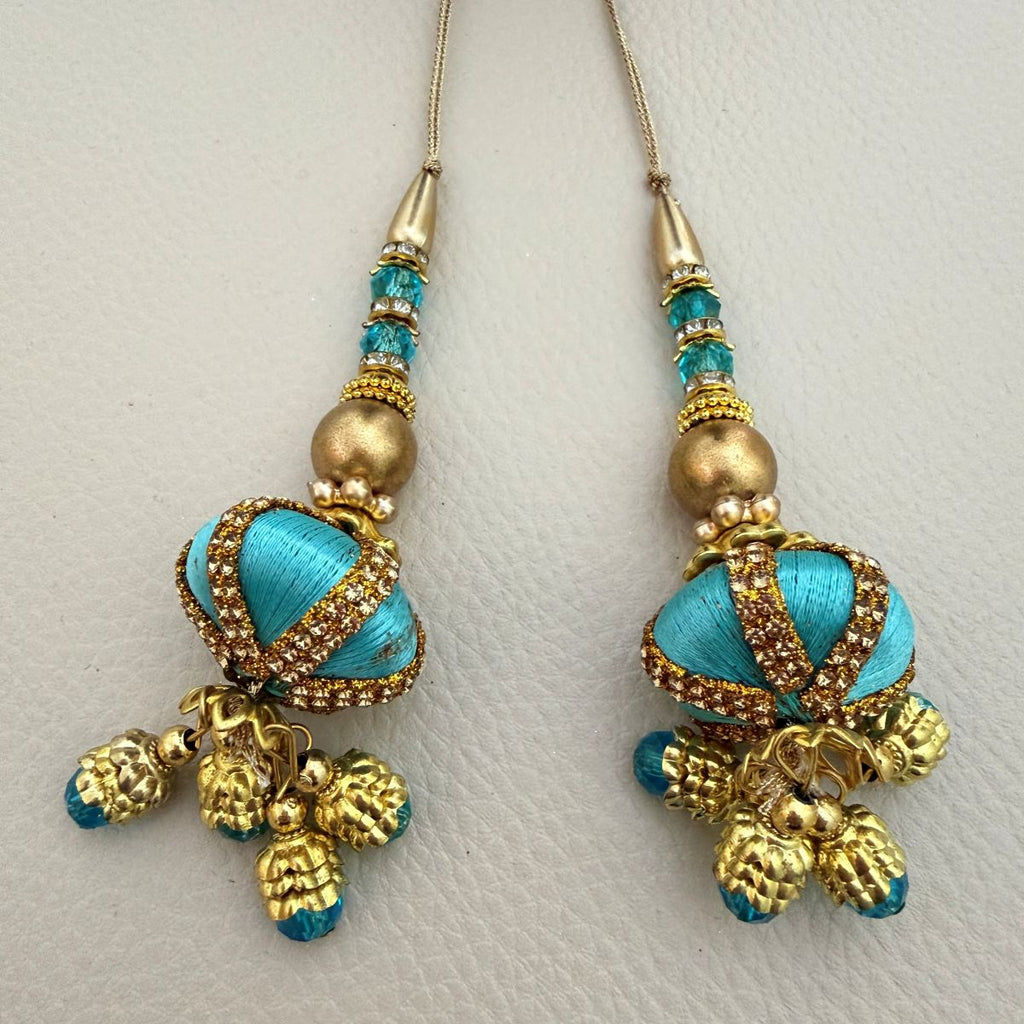 Pair of turquoise and antique gold beaded latkan tassels shown beside ruler