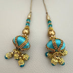 Pair of turquoise and antique gold beaded latkan tassels shown beside ruler