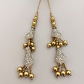 Two gold and silver embroidered tassel latkans beside a ruler