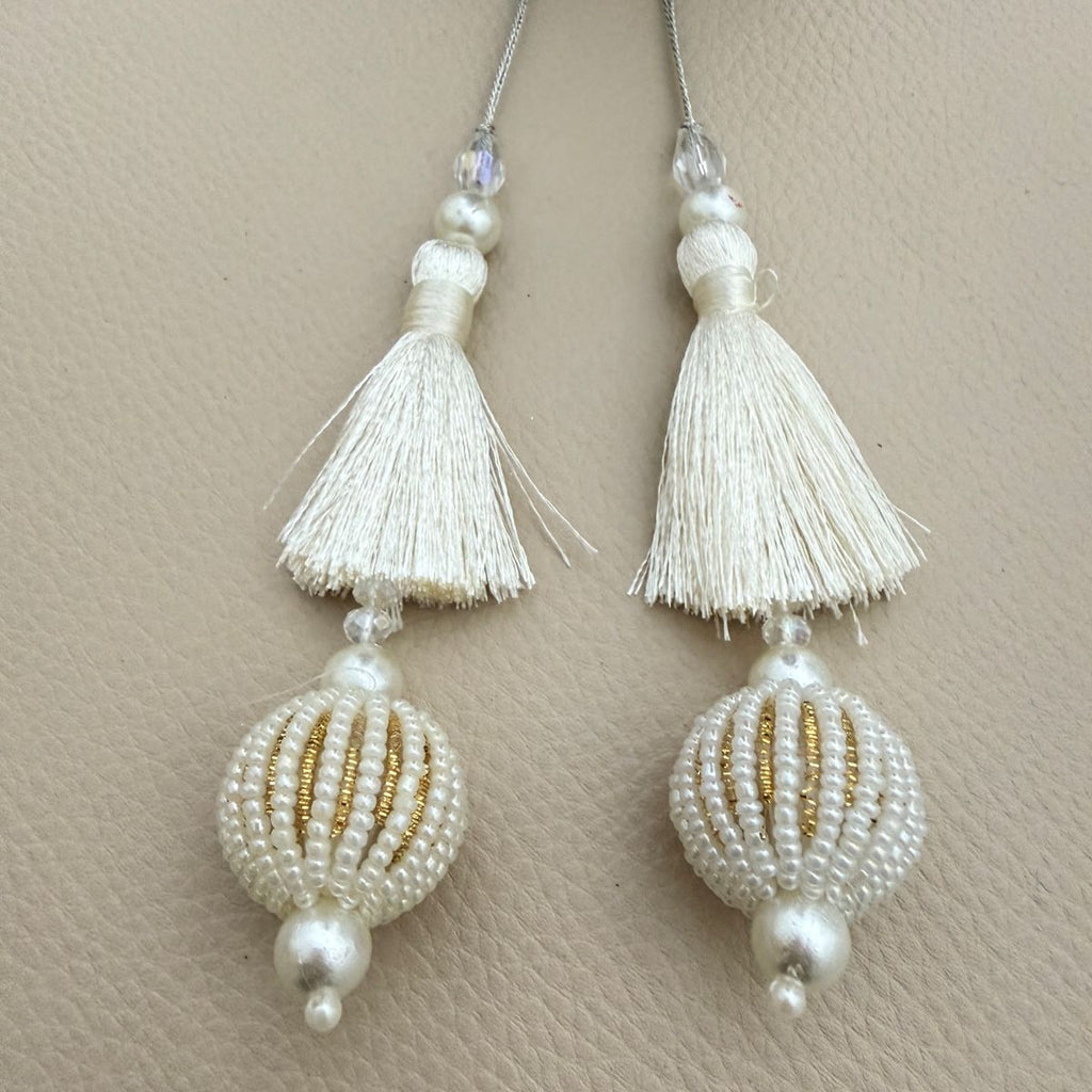 Pair of ivory thread tassels with pearl beads and white-and-gold beaded ball drops