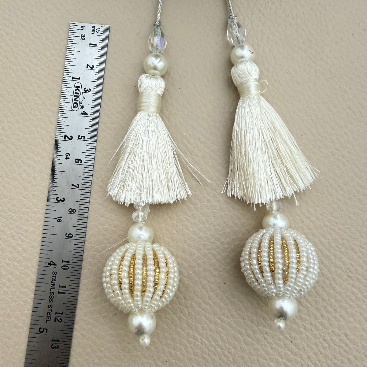 Group of ivory silk-thread latkan tassels with pearl and gold striped beadwork