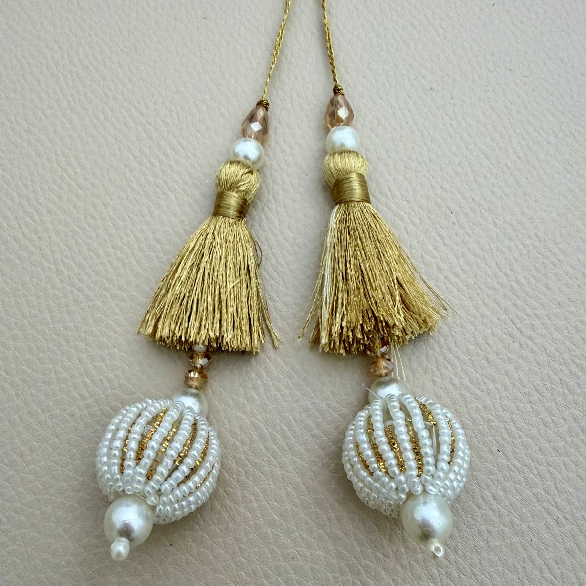 Group of gold thread latkan tassels with white seed-bead balls, pearl-look beads and champagne crystals