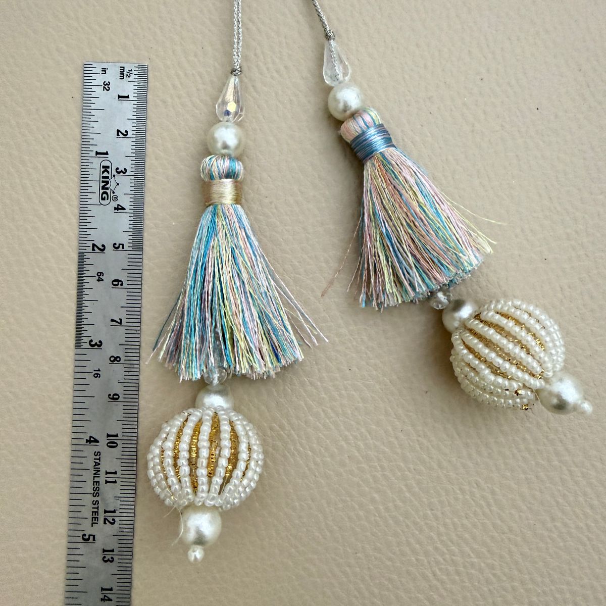 Pastel thread and beaded ball latkan beside ruler showing approximate decorative drop length