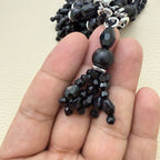 Close-up of the faceted black beads and layered tassel construction