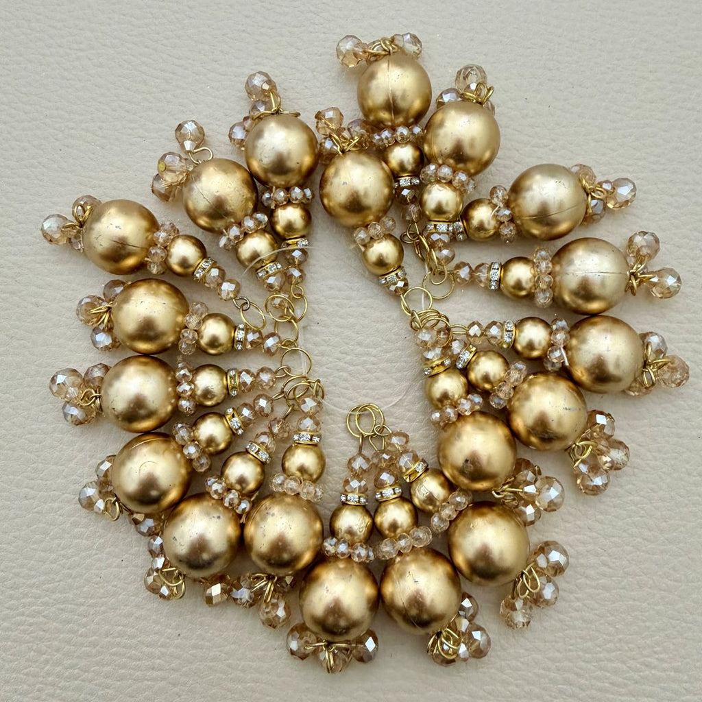 Close view of gold pearl-look tassel latkans with champagne faceted crystal-style bead clusters