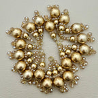 Close view of gold pearl-look tassel latkans with champagne faceted crystal-style bead clusters