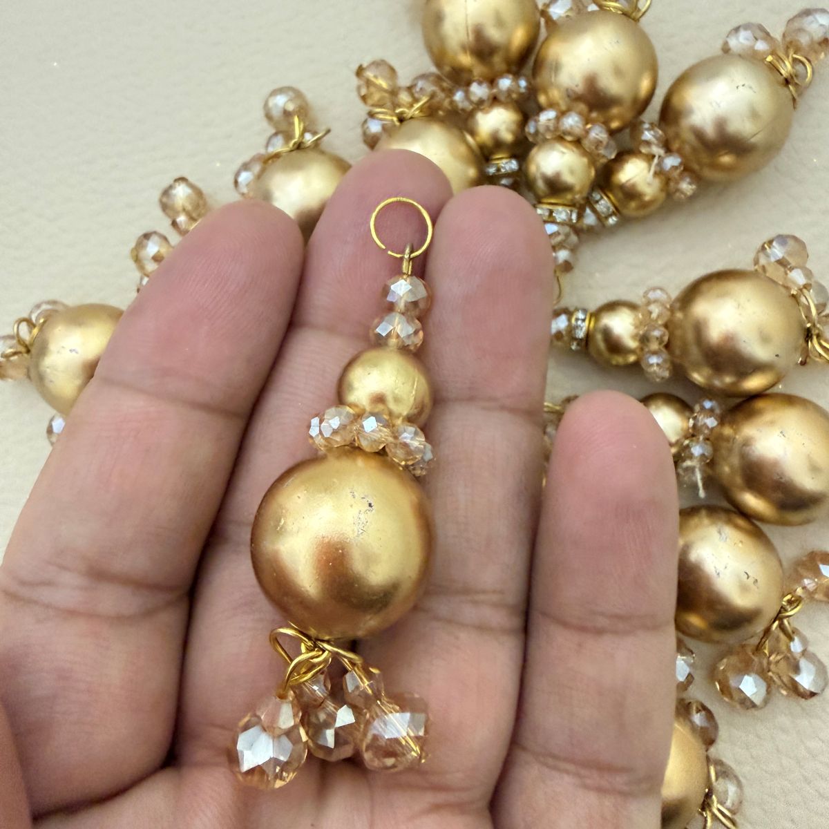 Single gold pearl-look tassel latkan with rhinestone spacer and clustered faceted bead drops