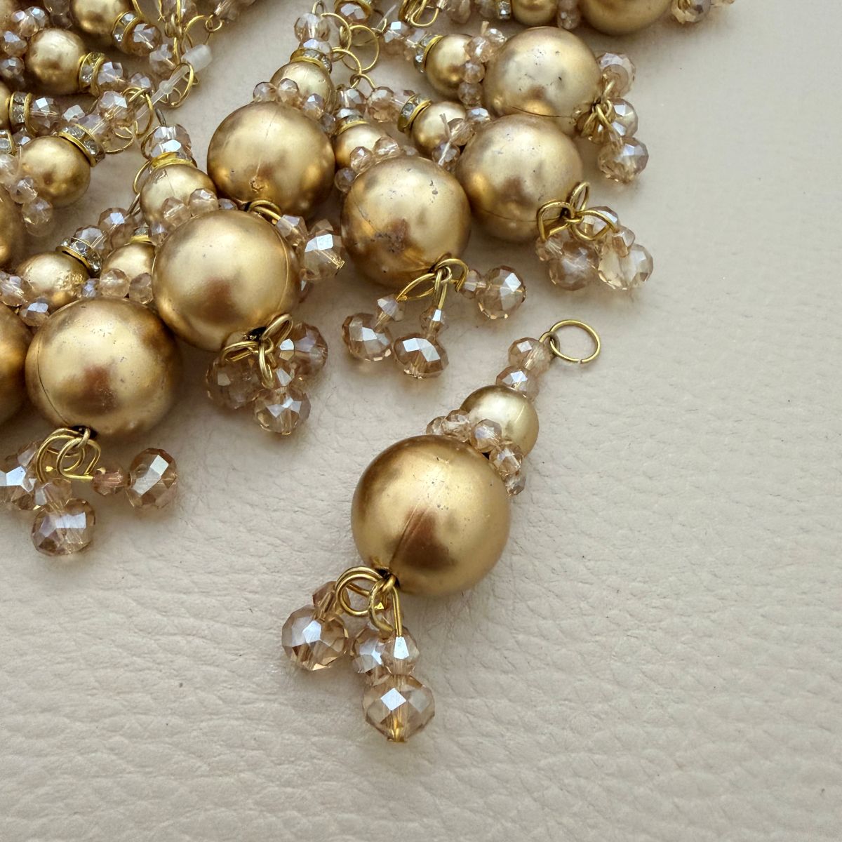 Gold pearl-look crystal bead tassel beside ruler measuring approximately 6 centimeters long