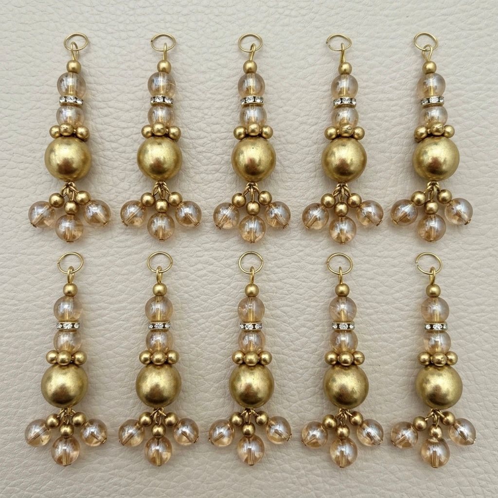 Single gold tone latkan showing clear beads, rhinestone spacer, and brushed gold center bead
