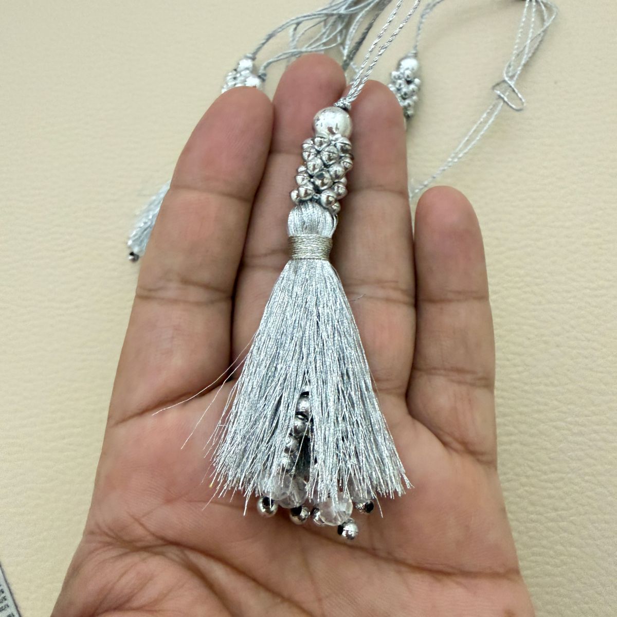 Bundle of silver silk tassels showing beaded caps