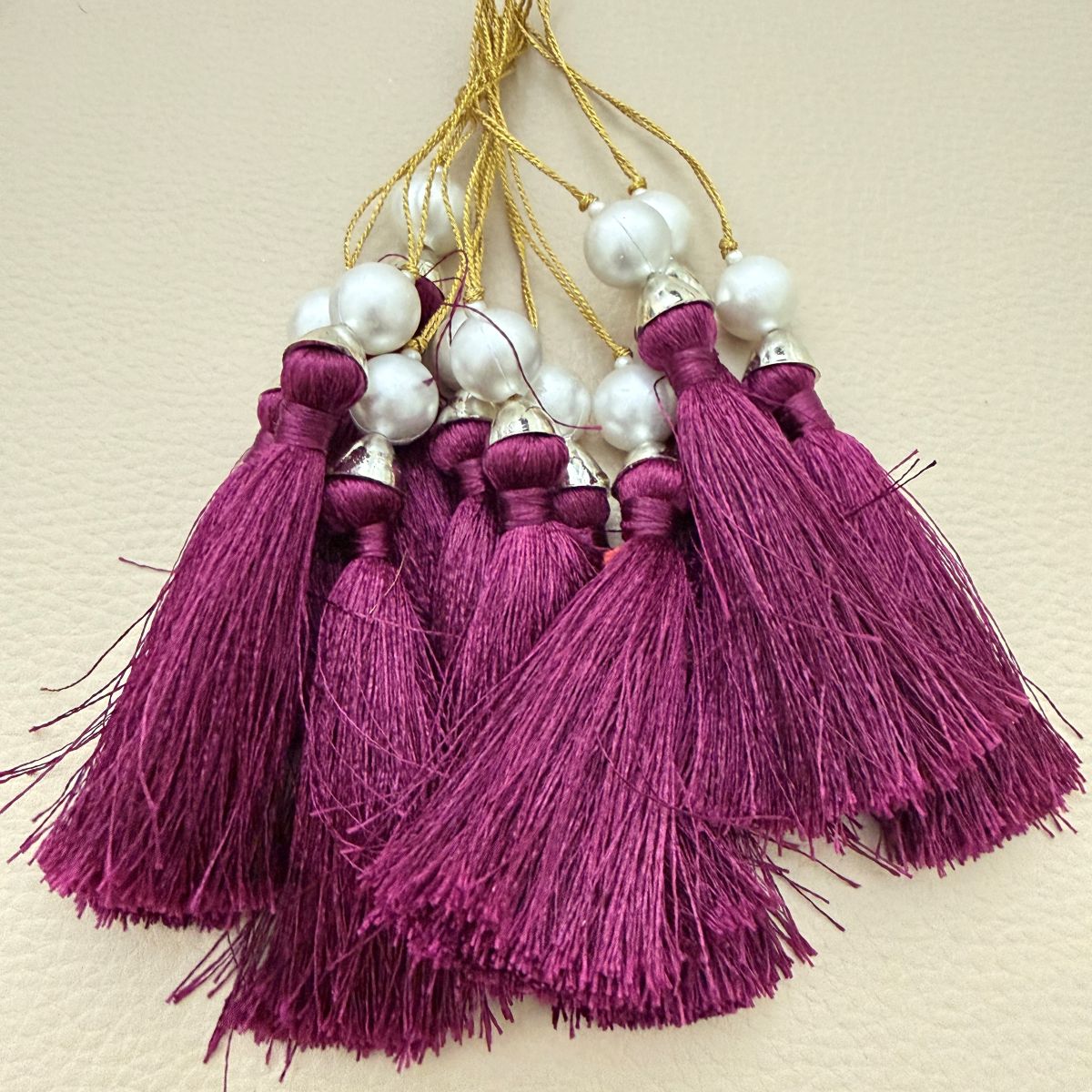 Rows of pink and plum tassels with looped cords and pearl-style beads