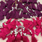 Single fuchsia pink tassel with pearl-style bead, metallic cap, and hanging loop
