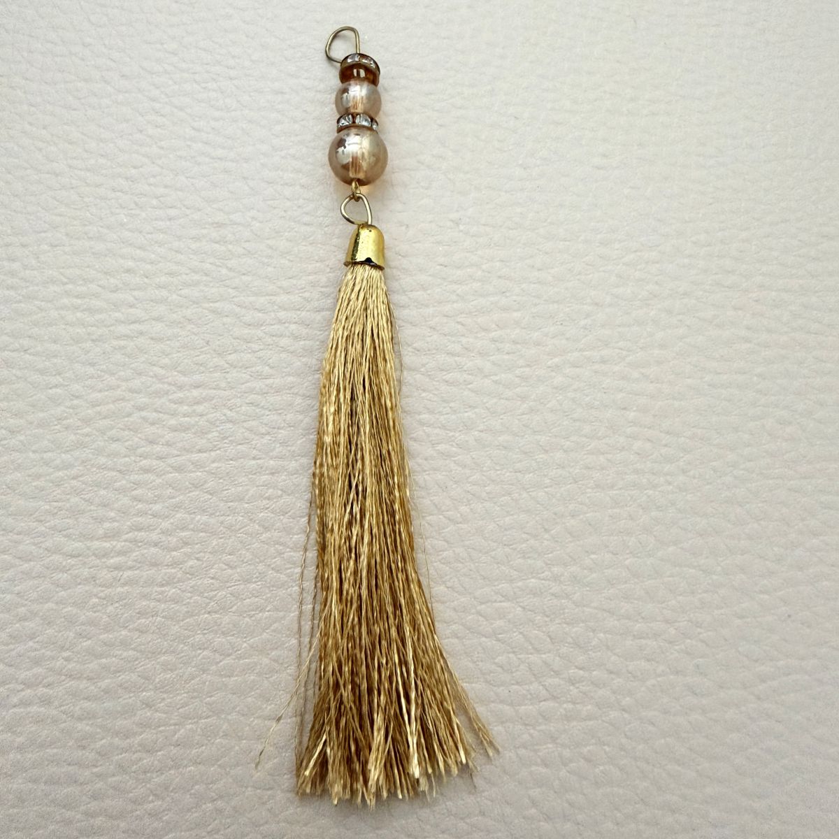 Set of gold thread tassels showing dense flowing fringe and beaded tops