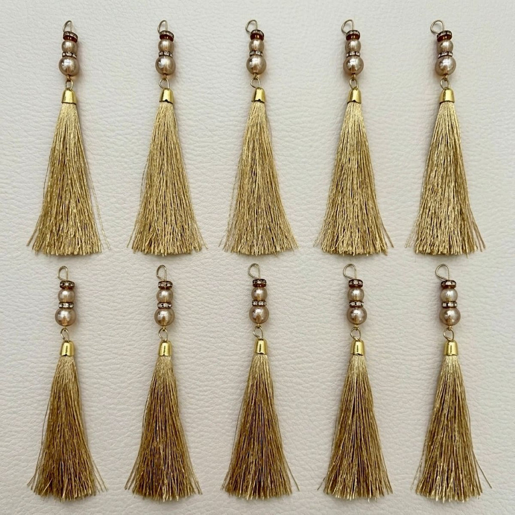 Group of gold thread tassels showing the fine strands and decorative beadwork