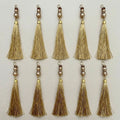 Group of gold thread tassels showing the fine strands and decorative beadwork