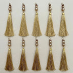 Group of gold thread tassels showing the fine strands and decorative beadwork
