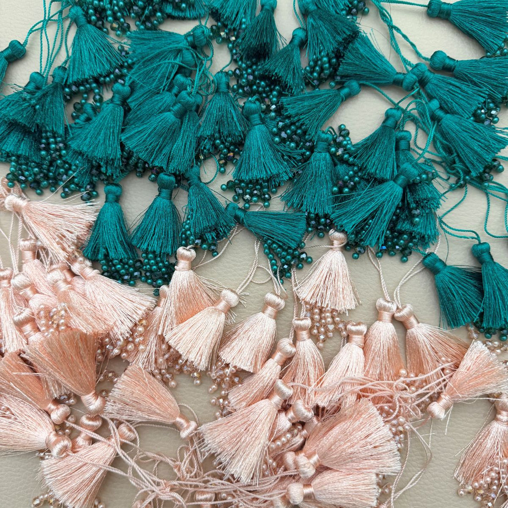 Teal green silk tassel latkan with pearl and crystal bead tips shown beside a ruler