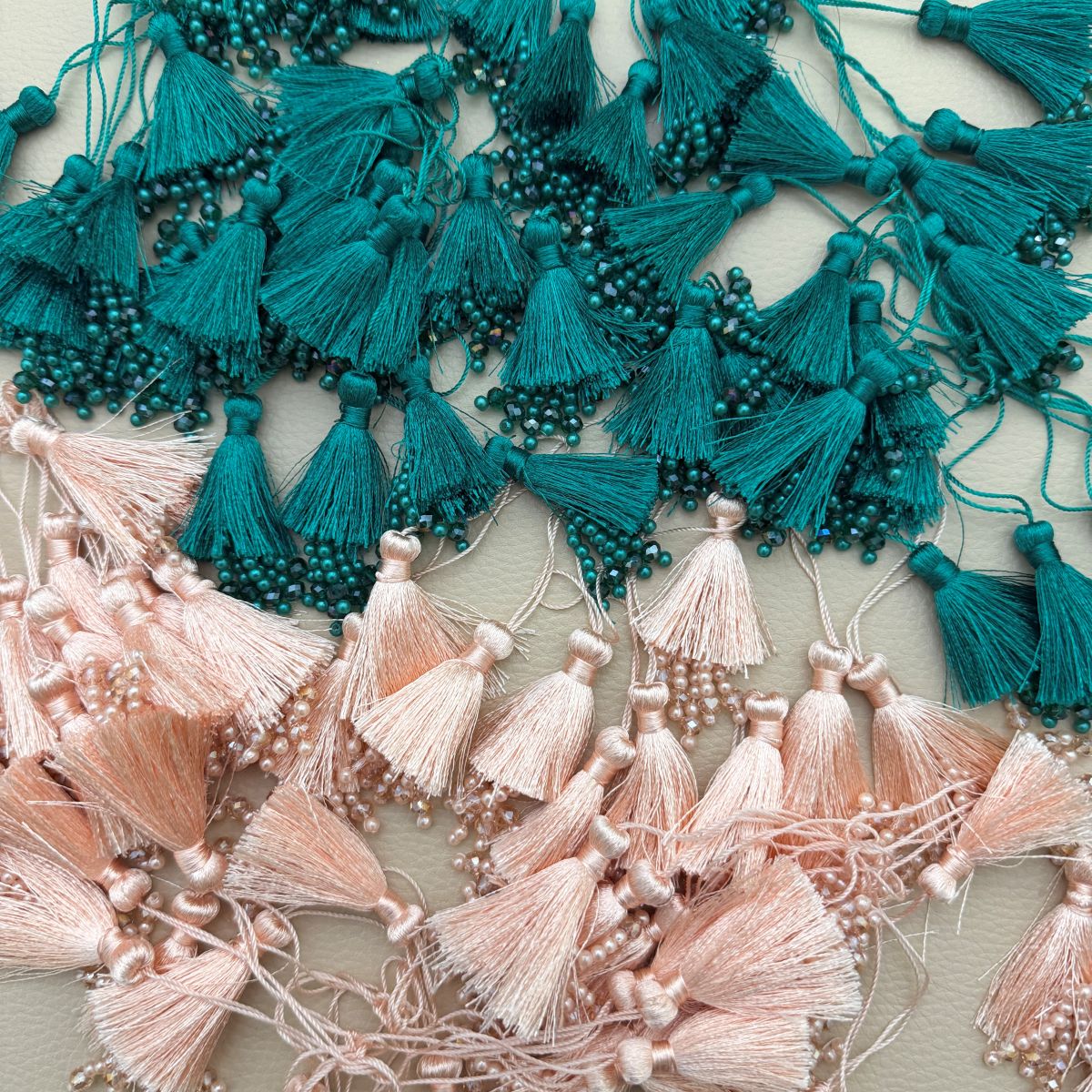 Teal green silk tassel latkan with pearl and crystal bead tips shown beside a ruler