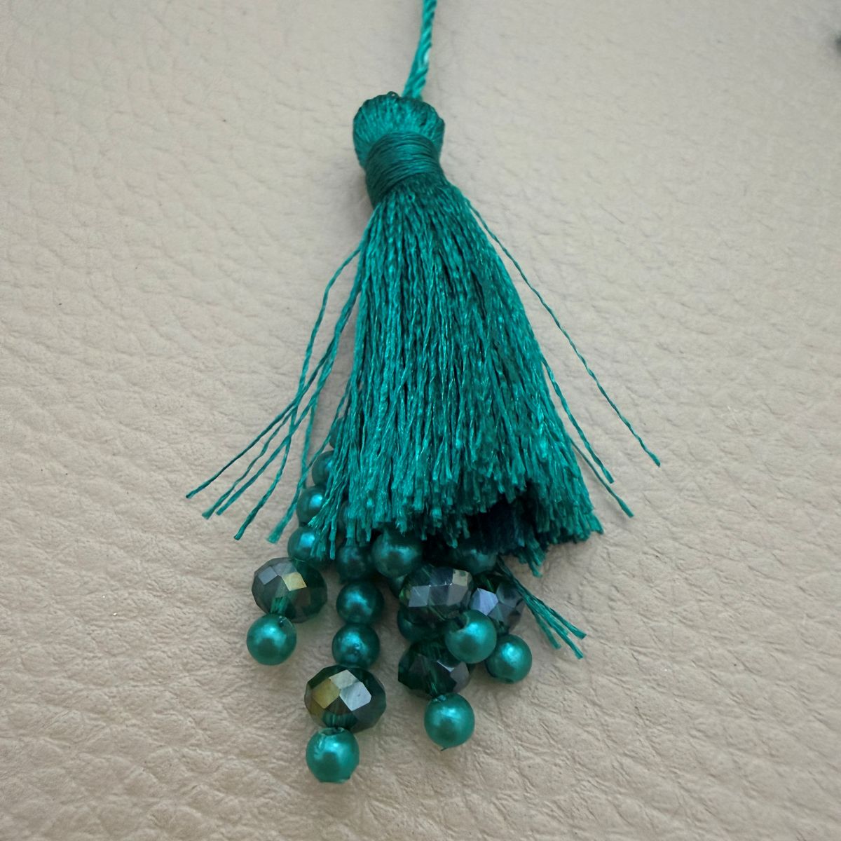 Close-up of blush peach silk tassel with pearl and crystal bead tips
