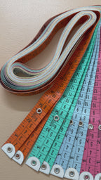 Yellow measuring tape with black text on a white background